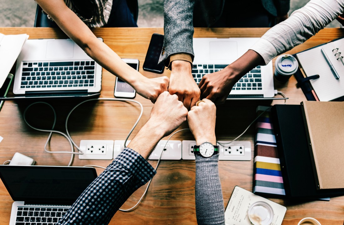 Personas chocando puños representando trabajo en equipo
